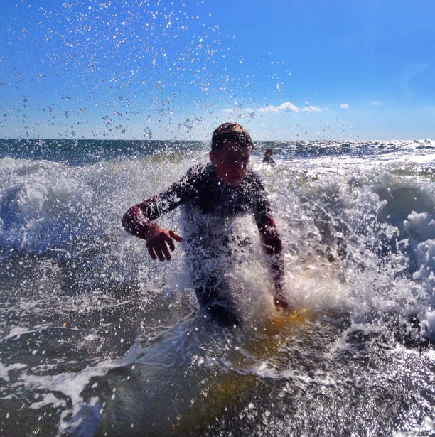 A young surfer wiping out very close to the camera