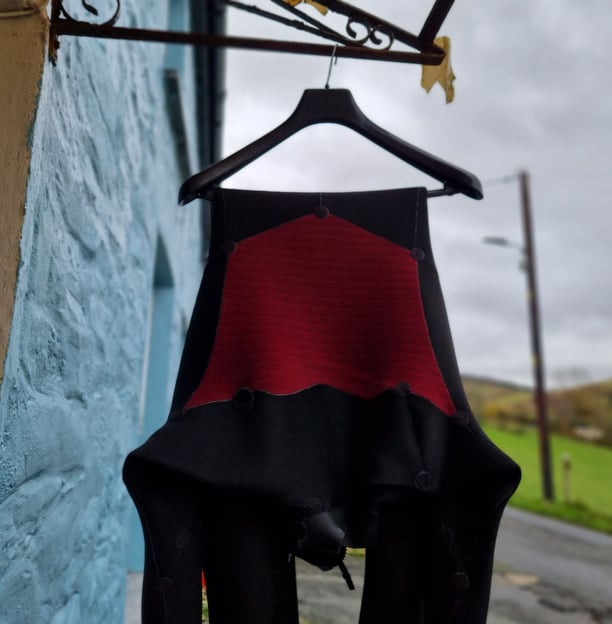 A wetsuit hanging up to dry on a clothes hanger