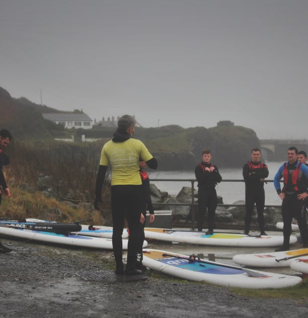 The rugby team getting intsruction from AberAdventures paddle board coaches