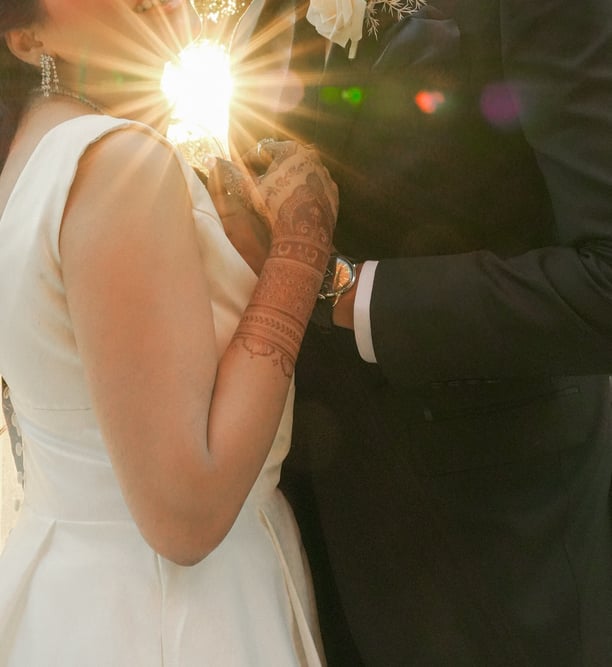 a bride and groom kissing in front of a tree