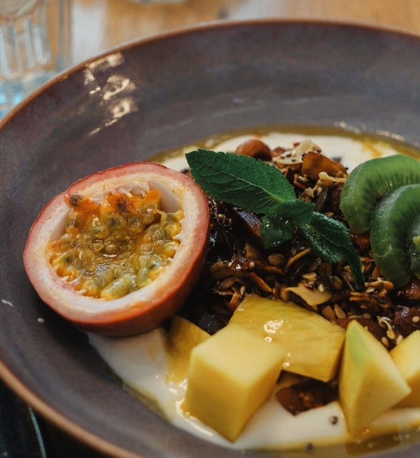 alt="Bol de yaourt gourmand garni de fruits frais , granola maison"
