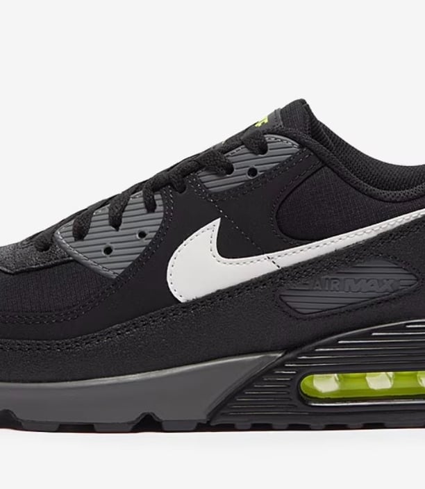 Nike Air Max 90 sneakers in black with neon yellow accents, visible Air cushioning, and mesh upper