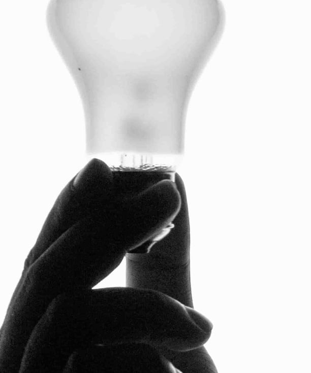 Creations and Solutions: a person holding a light bulb in their hand