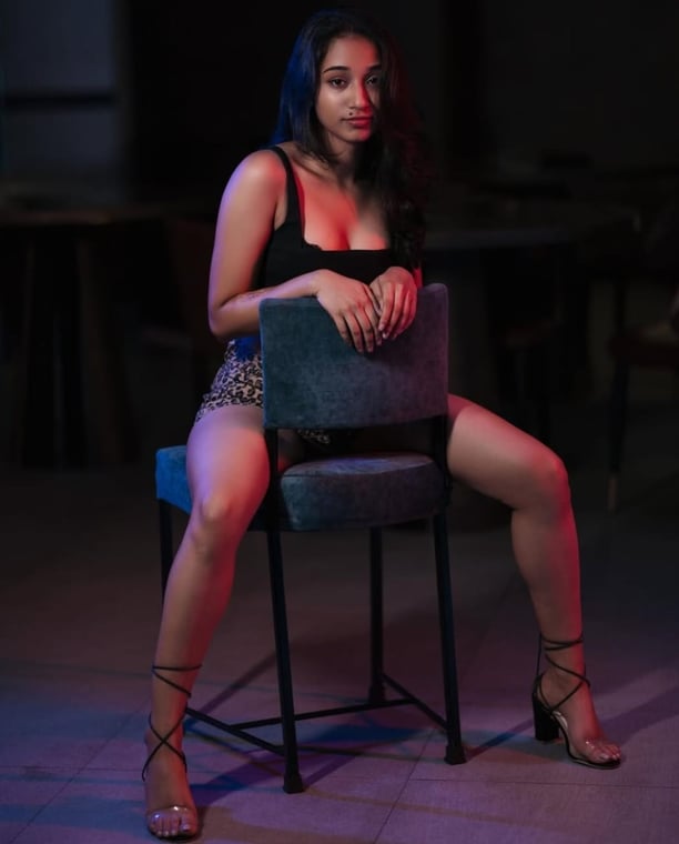 a Lanka Ads woman in a black dress sitting on a chair