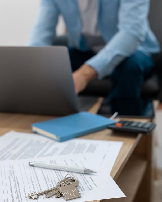 a person sitting at a table with a laptop and keys