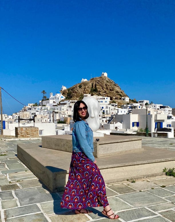 Une femme en robe devant un paysage de Grèce