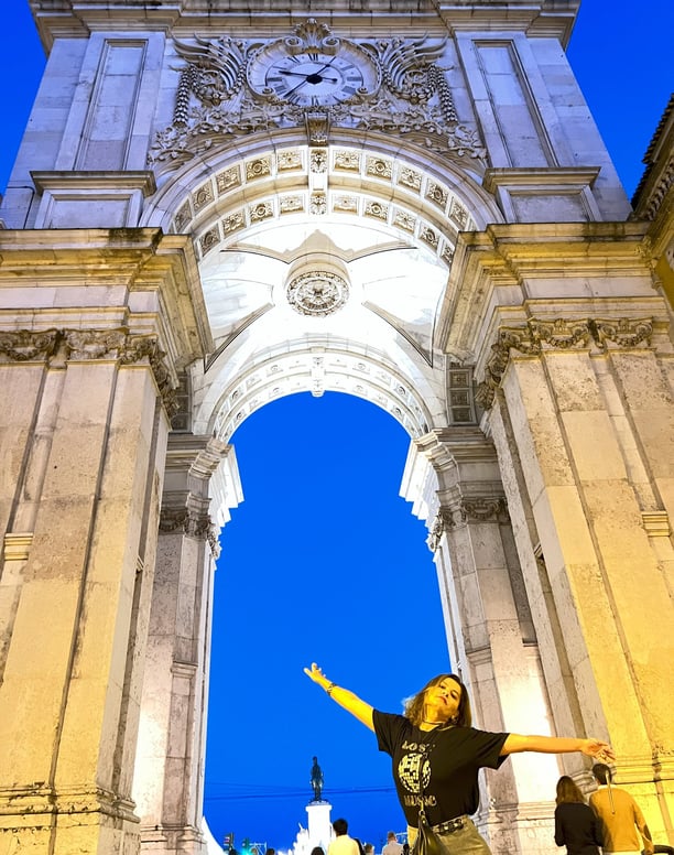 mulher em frente ao arco da rua Augusta em Lisboa Portugal