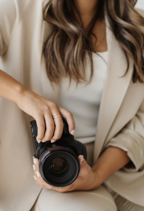 a woman sitting on a couch holding a camera