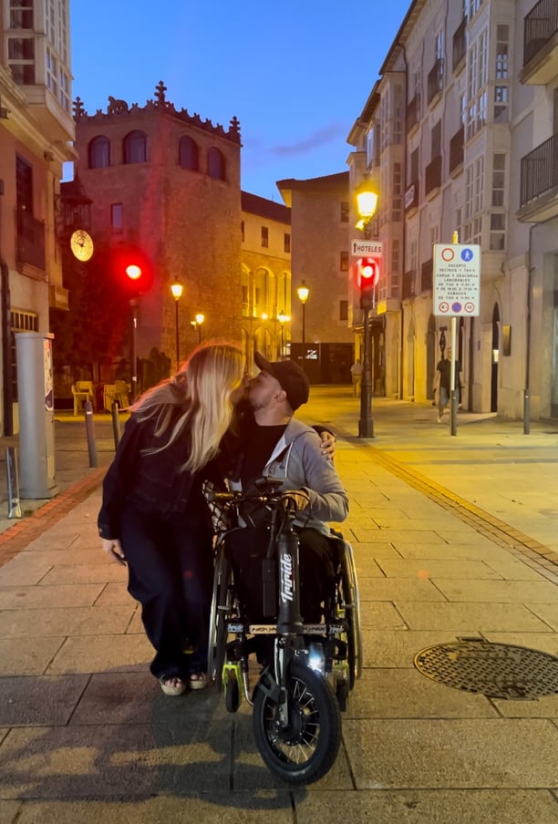 a man and woman kissing on a city street