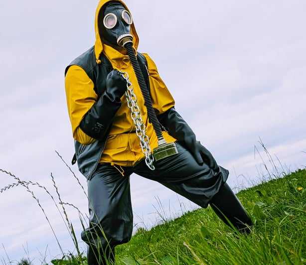 FTSH Studios model (s) Oscar Thickk UK Fetish Model wearing farmerrain bodysuit, raincoat, gloves, gas mask, chains