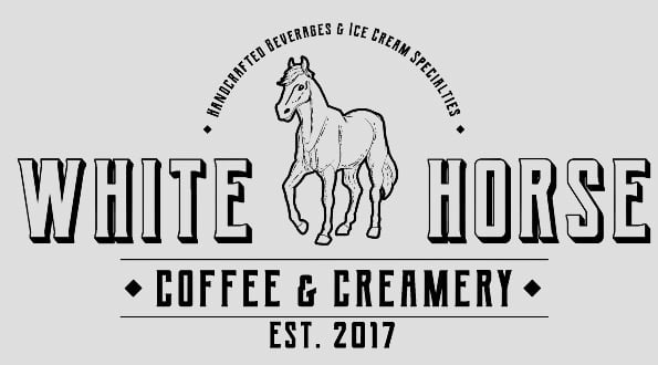 A logo with a white horse that says White Horse Cofee & Creamery