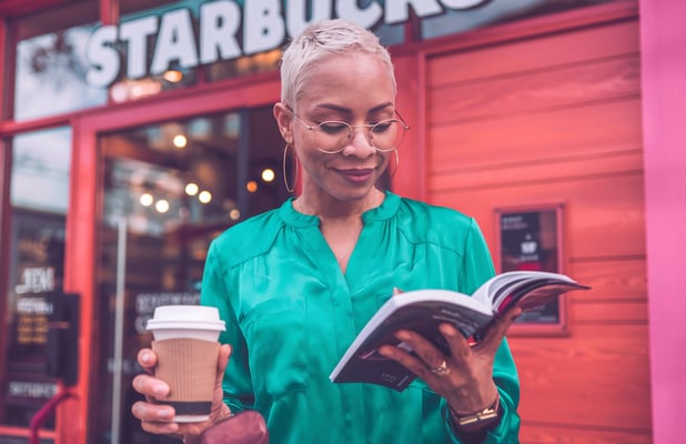 a woman in a green shirt is reading a book
