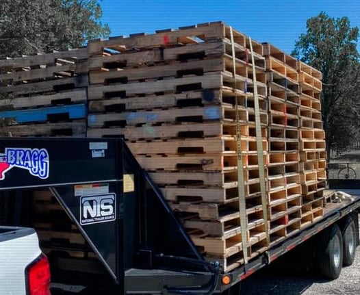 a truck with a load of used wood pallets on it