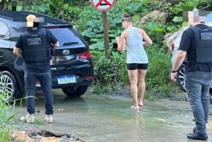 a group of police officers standing in front of a car