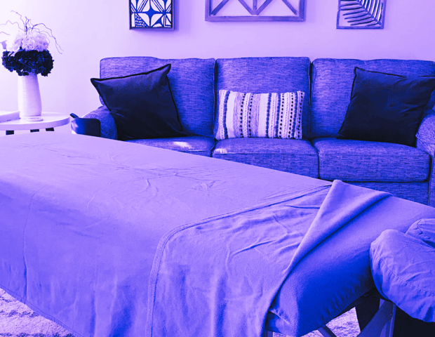 Massage table in a living room setting with a couch in the background