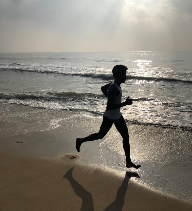 a person running on a beach near the ocean