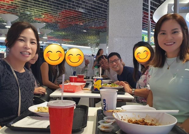 a group of people sitting at a table with smiley faces