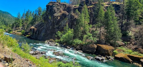 Waterfall Hwy, OR - Dark mountainous boulders, lush green trees, and a dazzling aqua river
