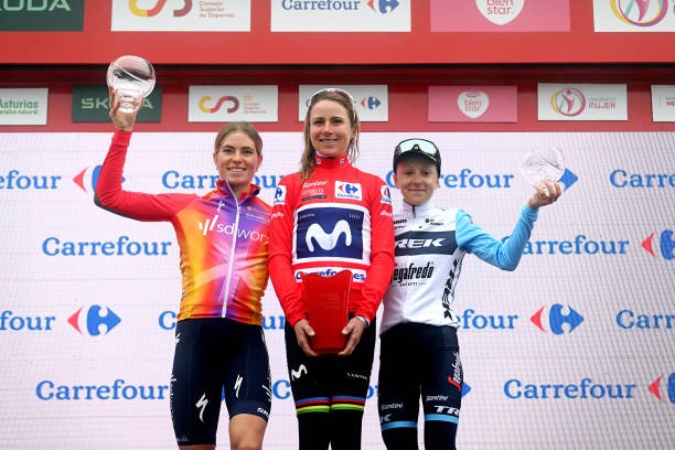 a woman standing on a podium with two other women