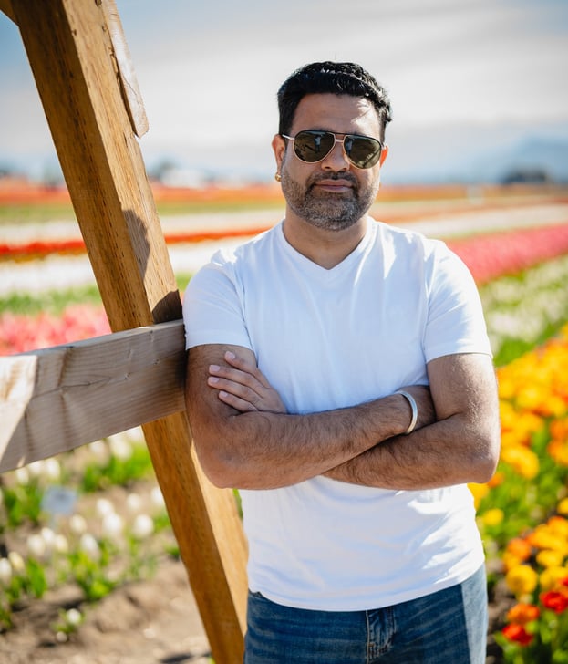 a man in sunglasses and standing in front of a wooden cross