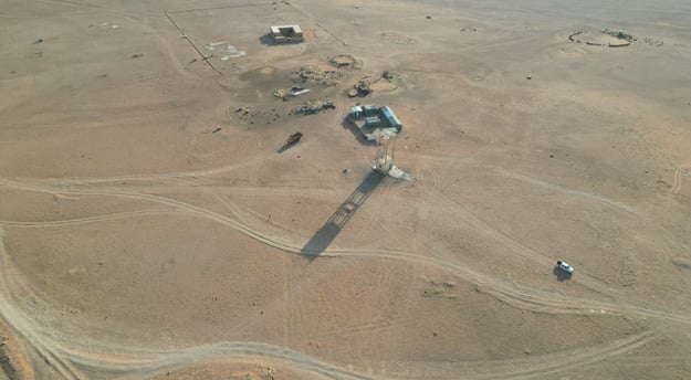 صورة جوية التُقطت باستخدام طائرة درون تُظهر منطقة صحراوية تحتوي على عدد من المباني البسيطة ومع