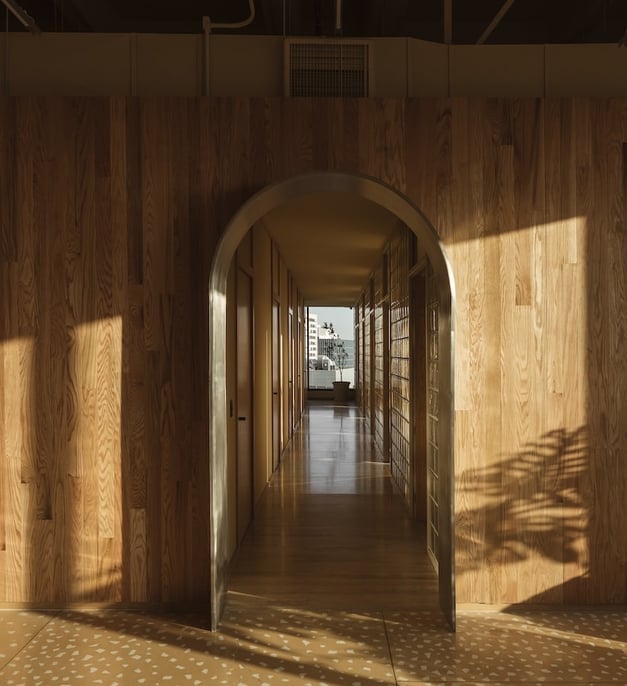 Wood-paneled clinic hallway with archways and city view – Fertilidad Integral in Mexico.