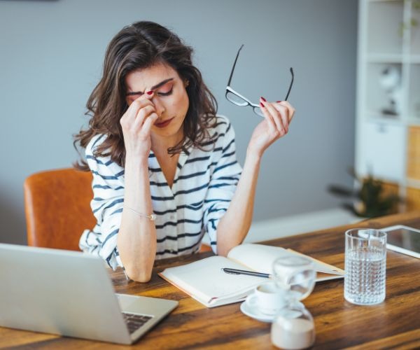 a woman with glasses and a laptop computer sitting at a table