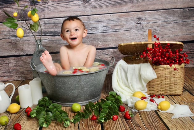 Séance photo bain de lait enfant, enfant dans une baignoire en étain avec des citrons