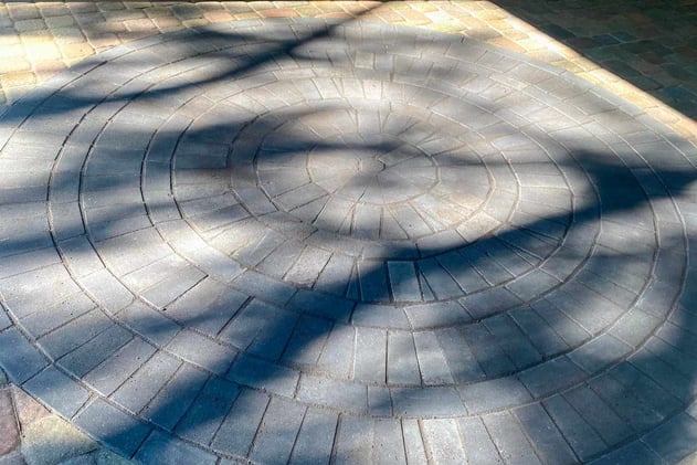Stamped concrete vs. wood decking vs. natural stone patio comparison.