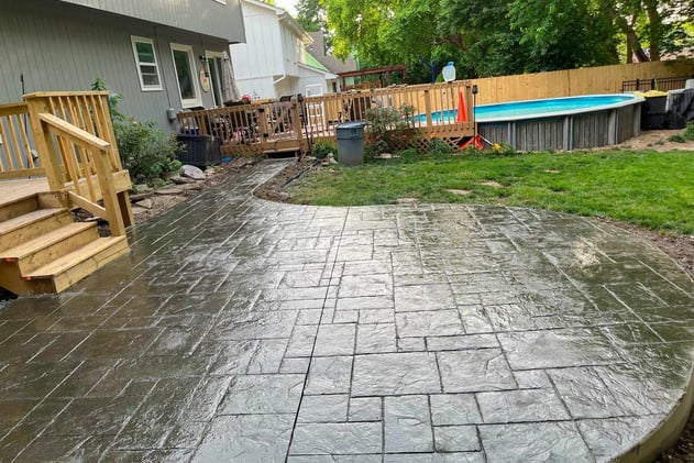 Durable stamped concrete patio in Kansas City with fire pit and outdoor furniture.