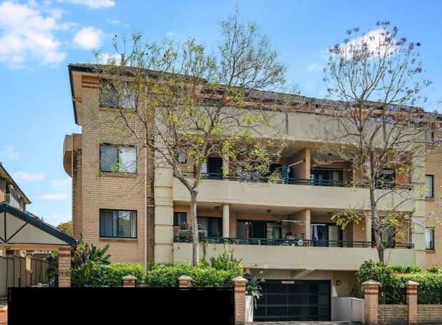 a large apartment building with a large balcony and a garage