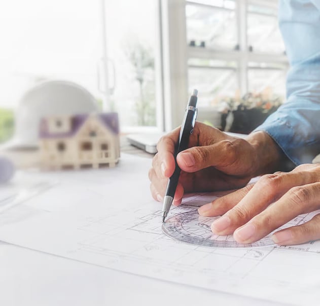 gros plan main écrivant sur un plan de construction
