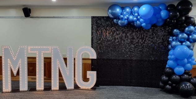 Black shimmer wall setup with a 4m balloon garland for a cheerleaders celebration in Springwood..