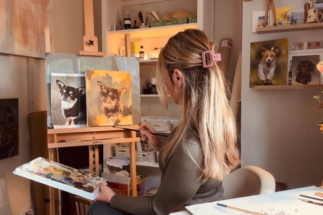 a woman is sitting in a chair and painting