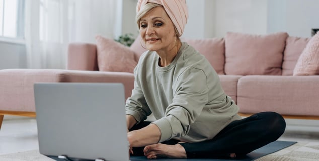Mujer adulta mayor en tapete de yoga participando en clase online de bienestar de Yarkeey