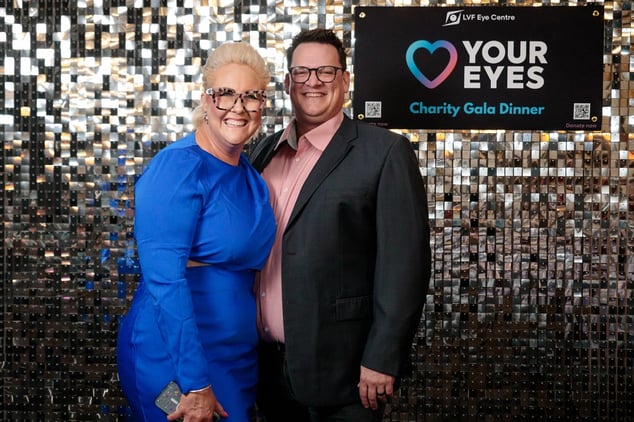 2 guests smiling in front of the SweetAz Co. silver shimmer wall hired for the Layton Vision Foundation Charity Gala Herston