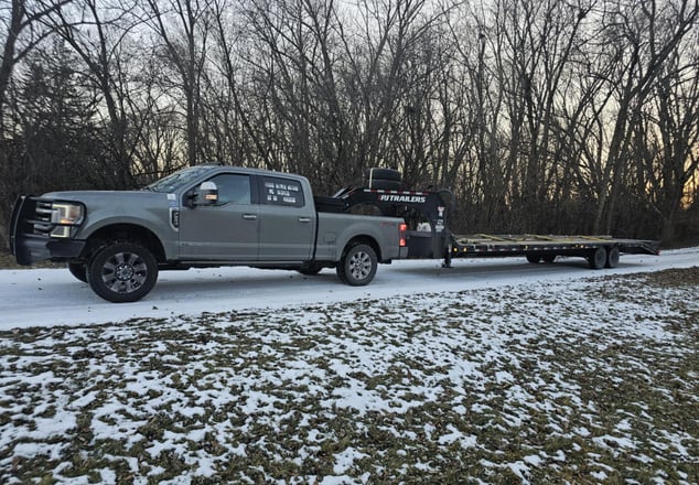 a truck with a flat bed and a flat bed, driving on snow