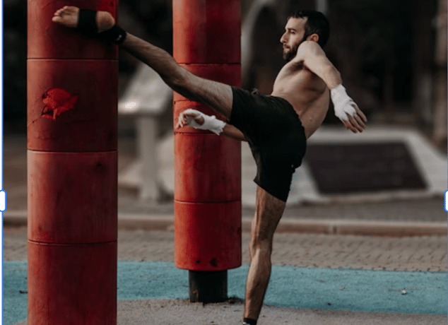 a man kicking a kickboxe in a gym
