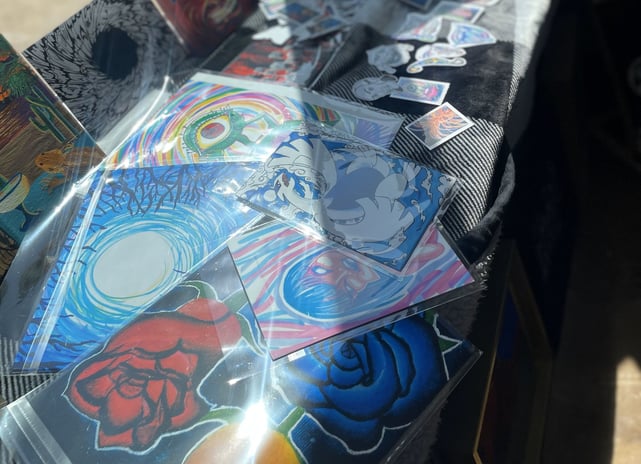 a table with a bunch of handmade art for sale!