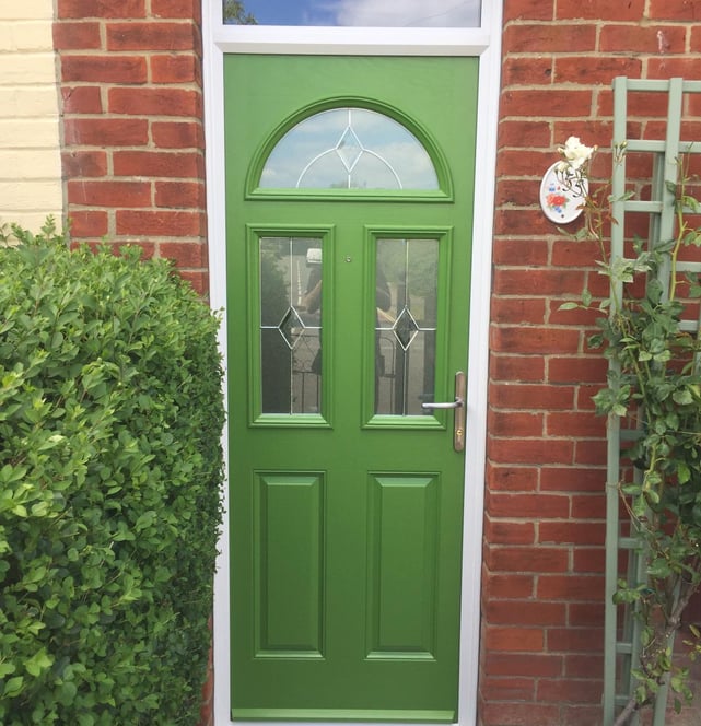 a bespoke bright green front door with diamond lead glass.  there are three windows on the door 
