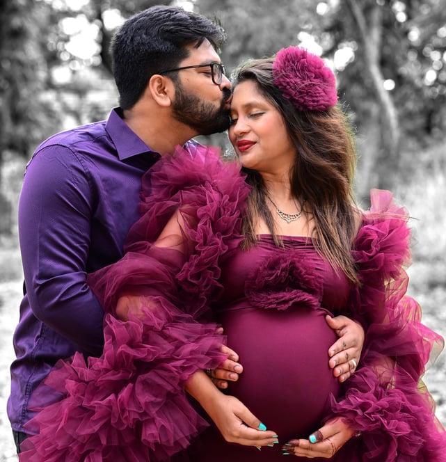 a pregnant woman and her husband are posing for a photo