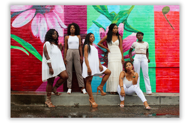 Black women standing in unity against a colorful mural, representing sisterhood, empowerment....