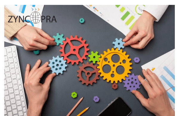 Manos conectando engranajes para simbolizar el proceso colaborativo de distribución en Zyncopra.