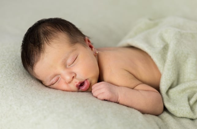 Sessió de fotos newborn a Girona amb una bebè recent nascuda dormint en estudi fotogràfic