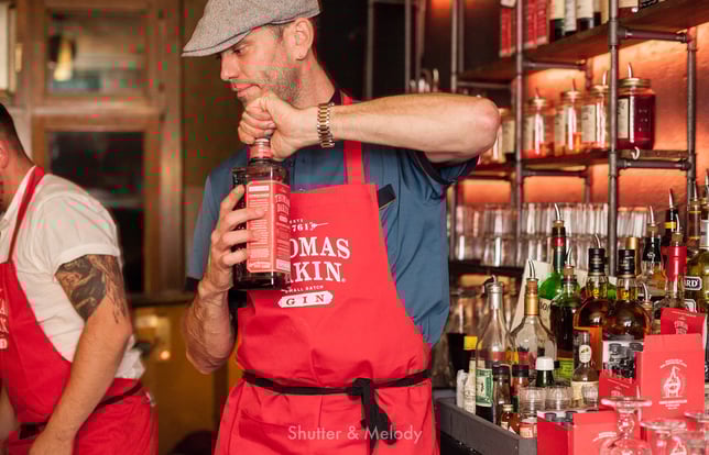 Thomas Dakin öffnet stellvertretend eine Flasche Gin.