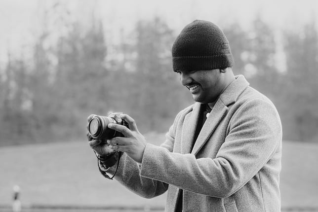 a man in a coat and hat is holding a camera