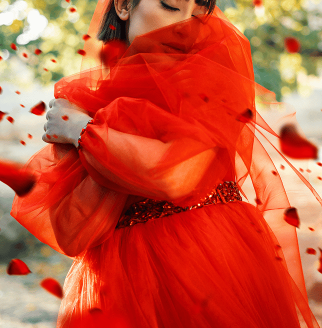 Empowered woman in red flowy dress, symbolizing a Phoenix rising as financial and spiritual freedom
