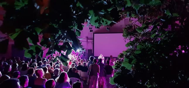 a crowd of people standing in front of a screen