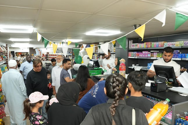 customers being served inside a busy convenience shop