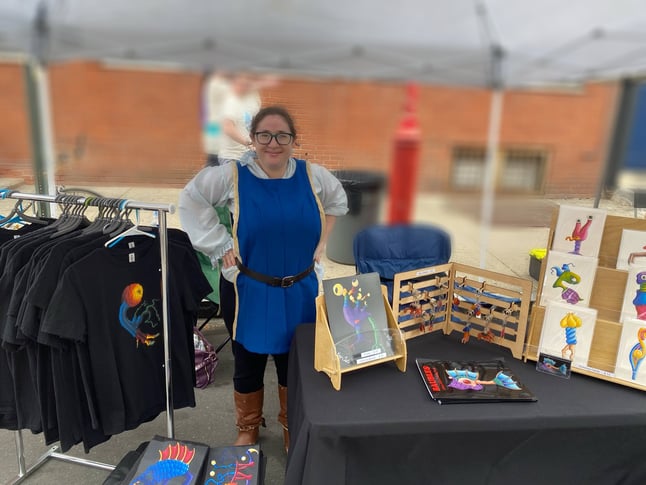 Rose wearing garb at their booth at Queen and Rook Fantasy Renn Faire
